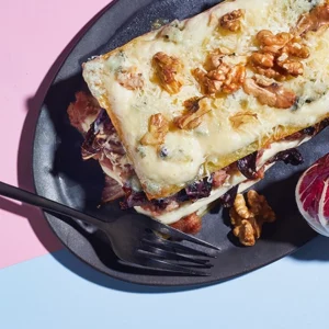 Lasagne auf einem Teller mit Walnüssen dekoriert