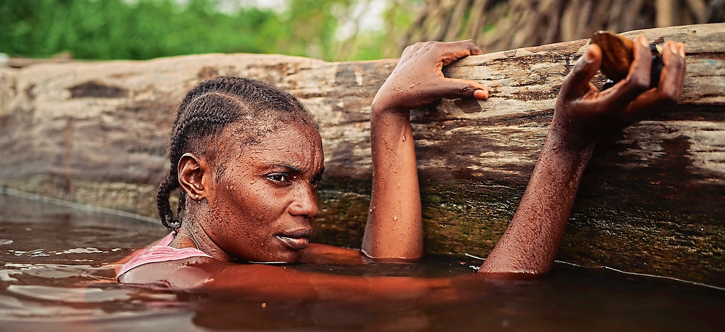 Eine Muscheltaucherin im Wasser