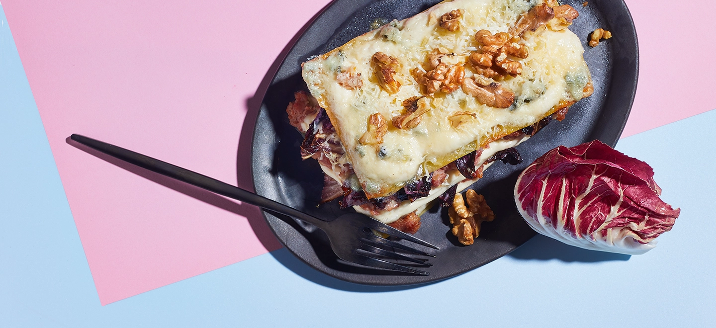 Lasagne auf einem Teller mit Walnüssen dekoriert