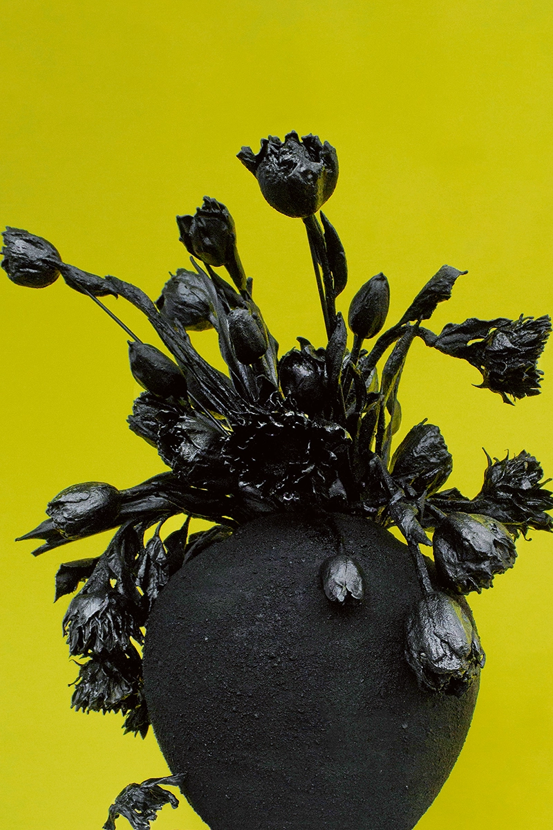 Schwarze Blumen vor gelbem Hintergrund