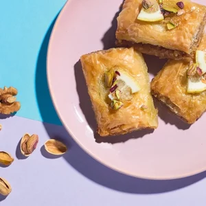 Baklava auf einem Teller vor buntem Hintergrund