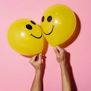 Zwei gelbe Ballons mit Smileys